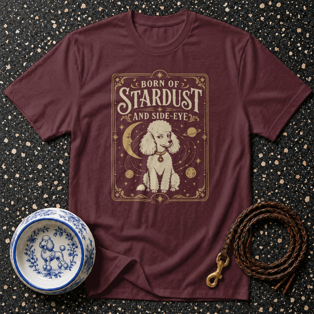 Maroon t-shirt with white poodle graphic and text "BORN OF STARDUST AND SIDE-EYE".