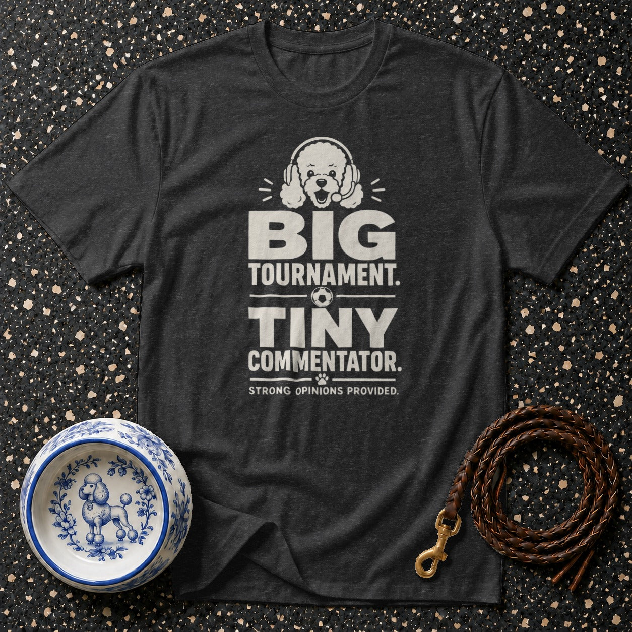 Dark t-shirt with "BIG TOURNAMENT. TINY COMMENTATOR. STRONG OPINIONS PROVIDED." text and poodle graphic.