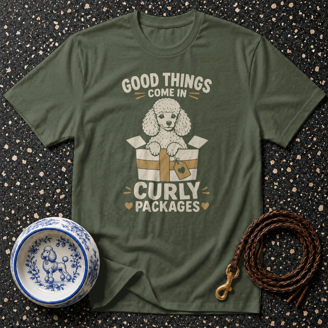 Olive green t-shirt with a white poodle in a box and text "Good things come in curly packages."
