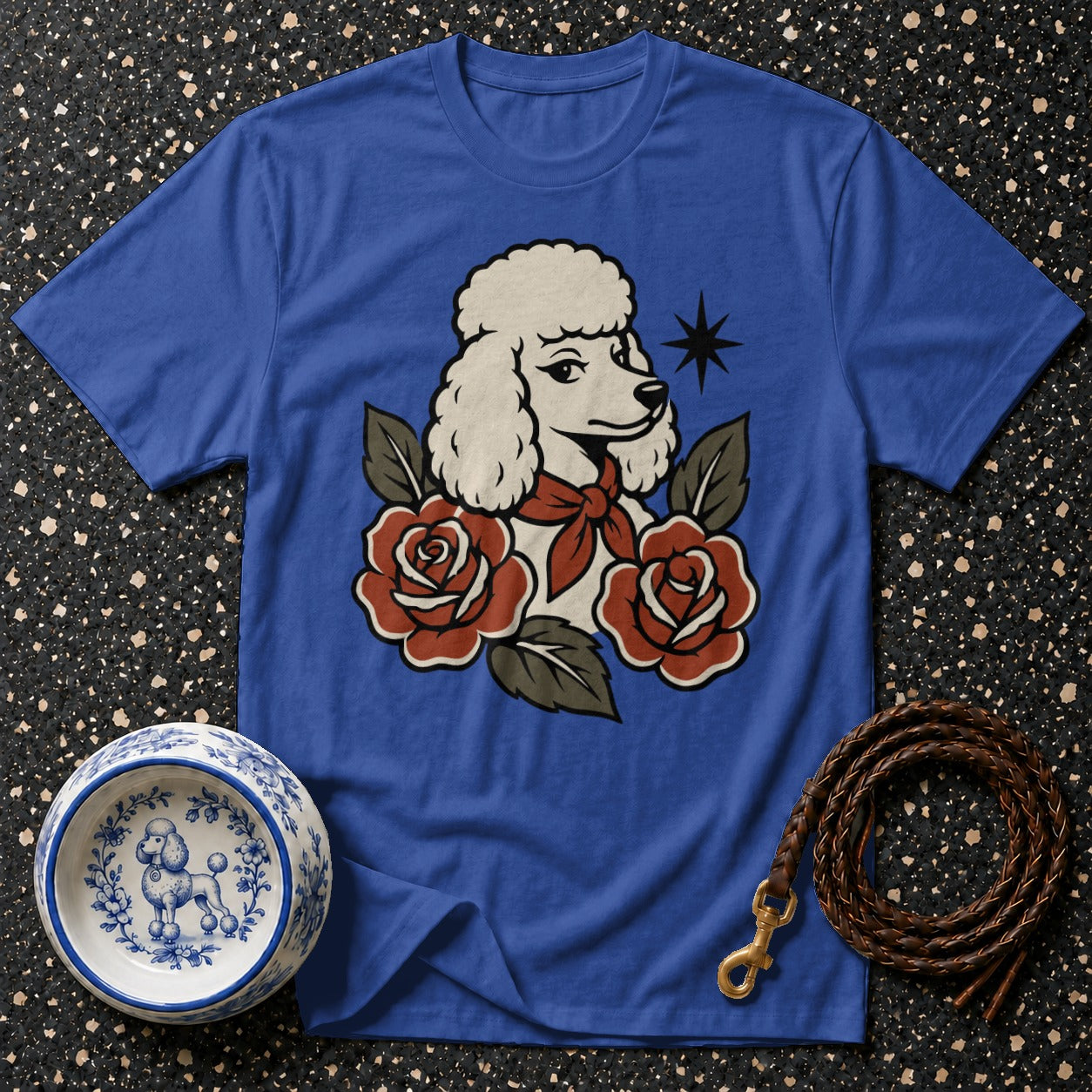 Blue t-shirt with poodle and roses graphic, ceramic dog bowl, and leather leash.