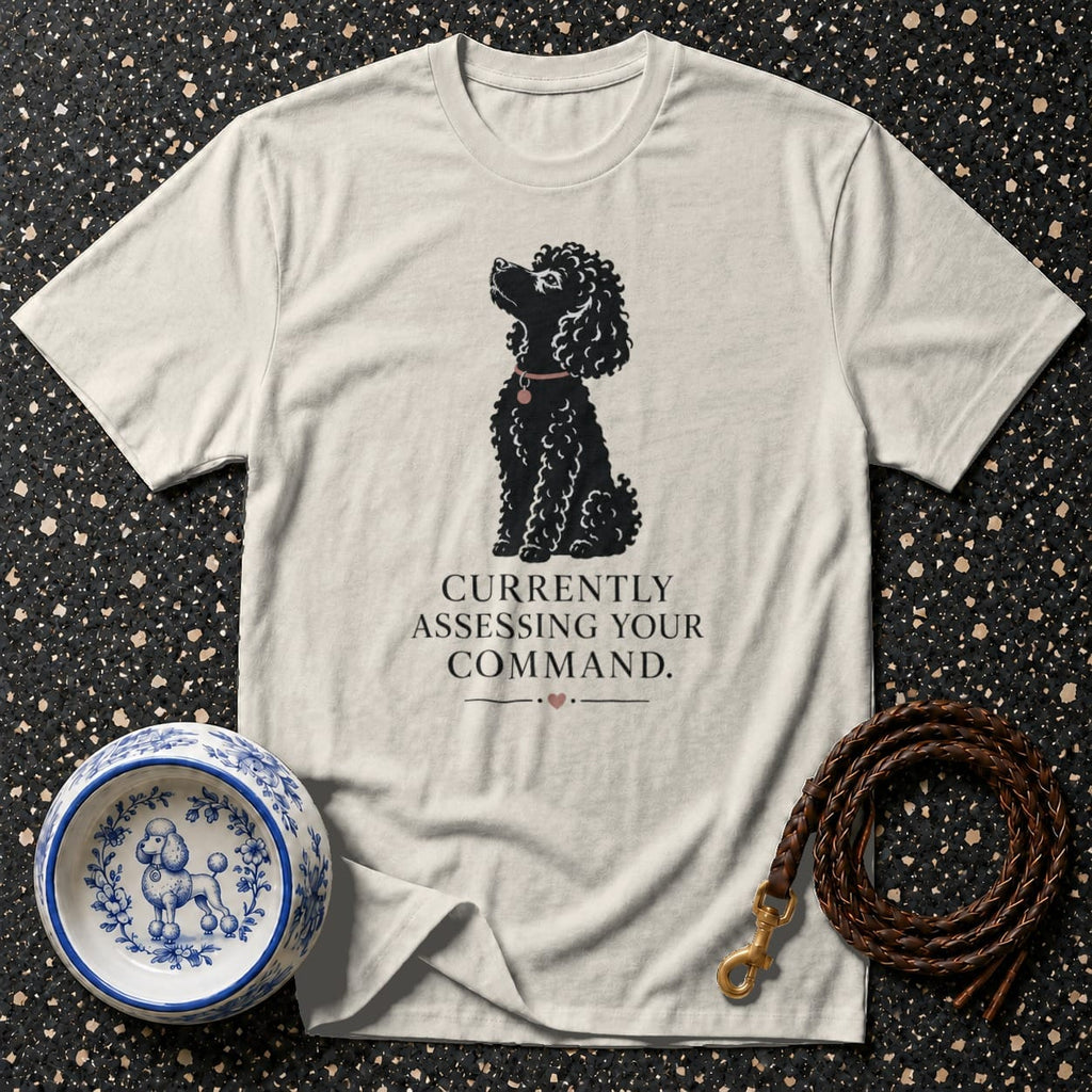 T-shirt with black poodle graphic and text "Currently Assessing Your Command."
