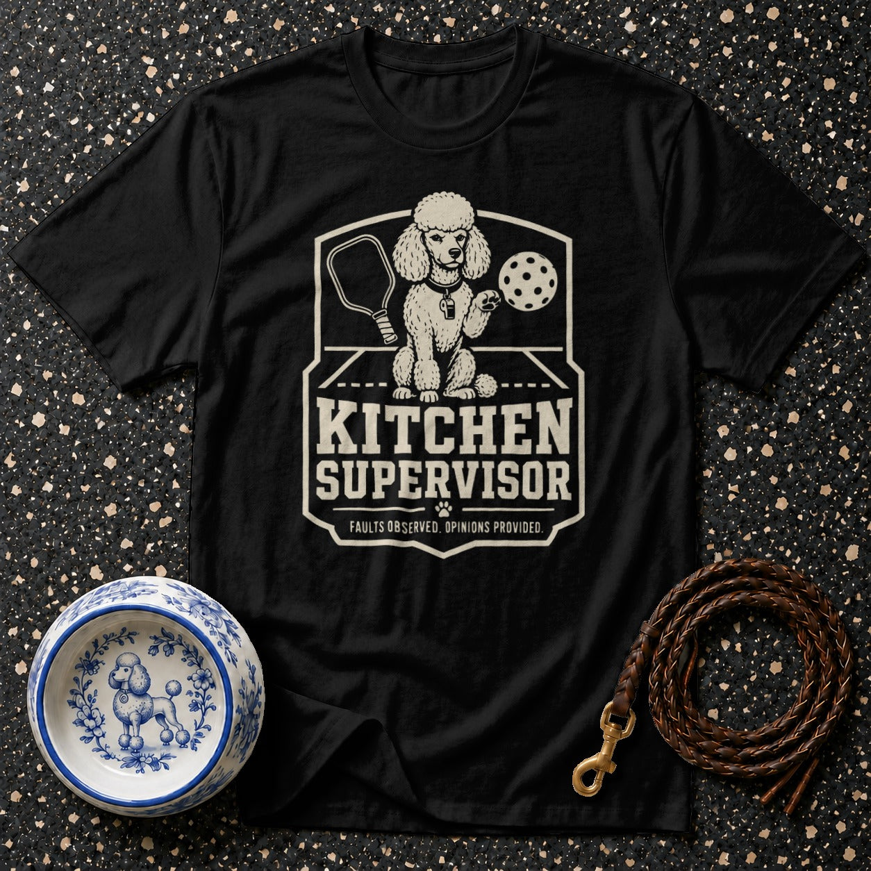 Black t-shirt with a graphic of a poodle holding a pickleball paddle and ball.