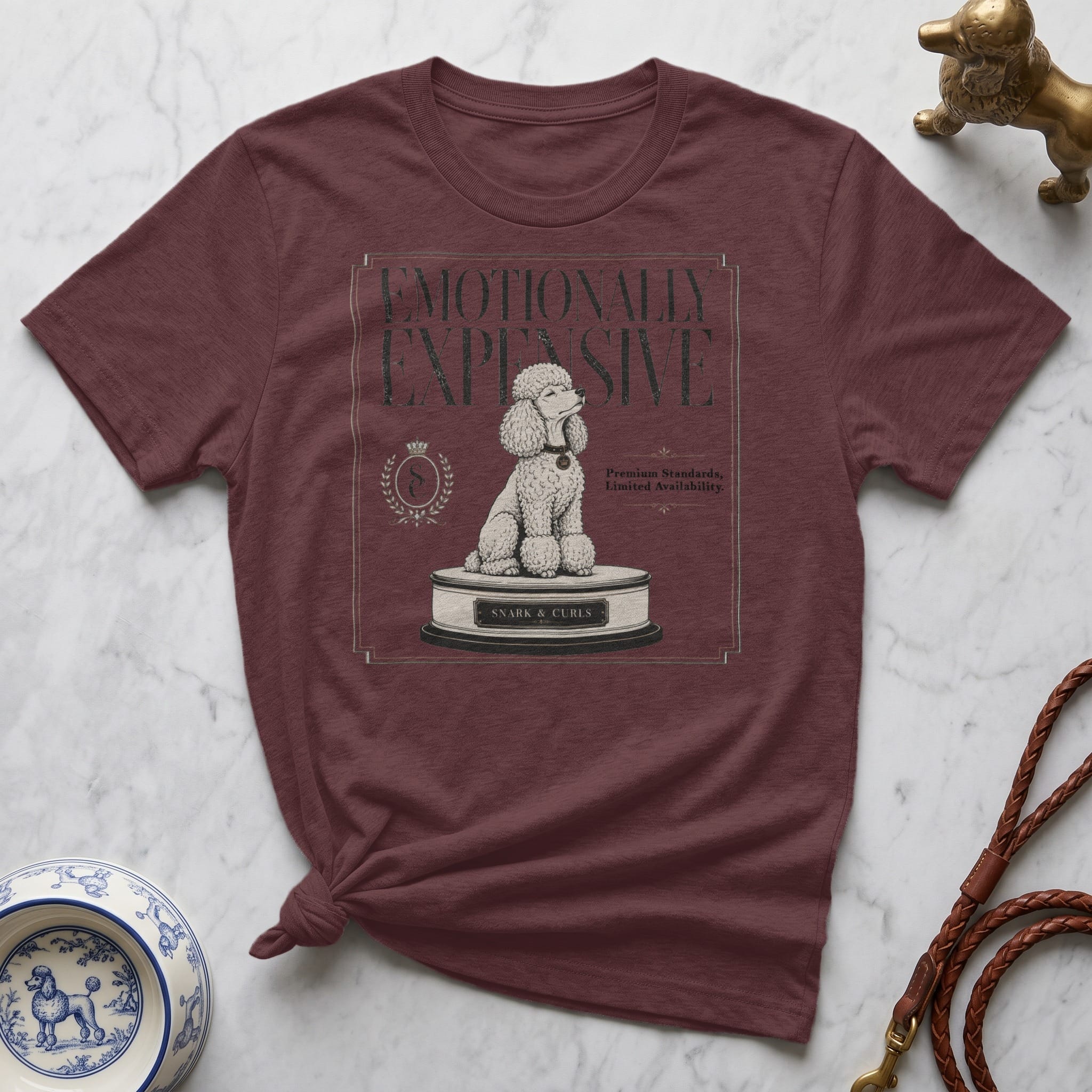 Maroon t-shirt with text "EMOTIONALLY EXPENSIVE" and a poodle on a pedestal.