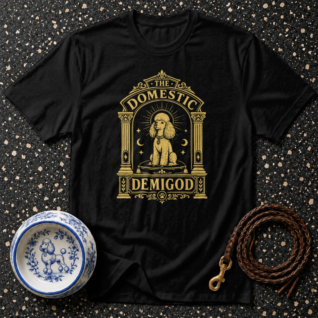 Black t-shirt with gold poodle graphic reading "The Domestic Demigod".