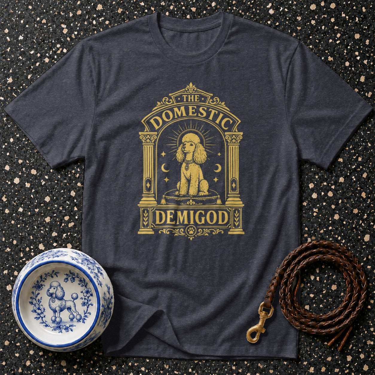 Dark grey t-shirt with gold poodle graphic reading "The Domestic Demigod."