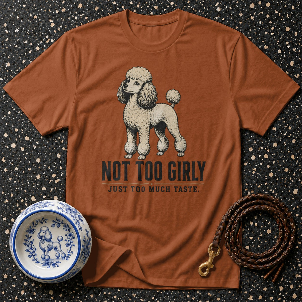 Brown t-shirt with a poodle illustration and text "NOT TOO GIRLY".