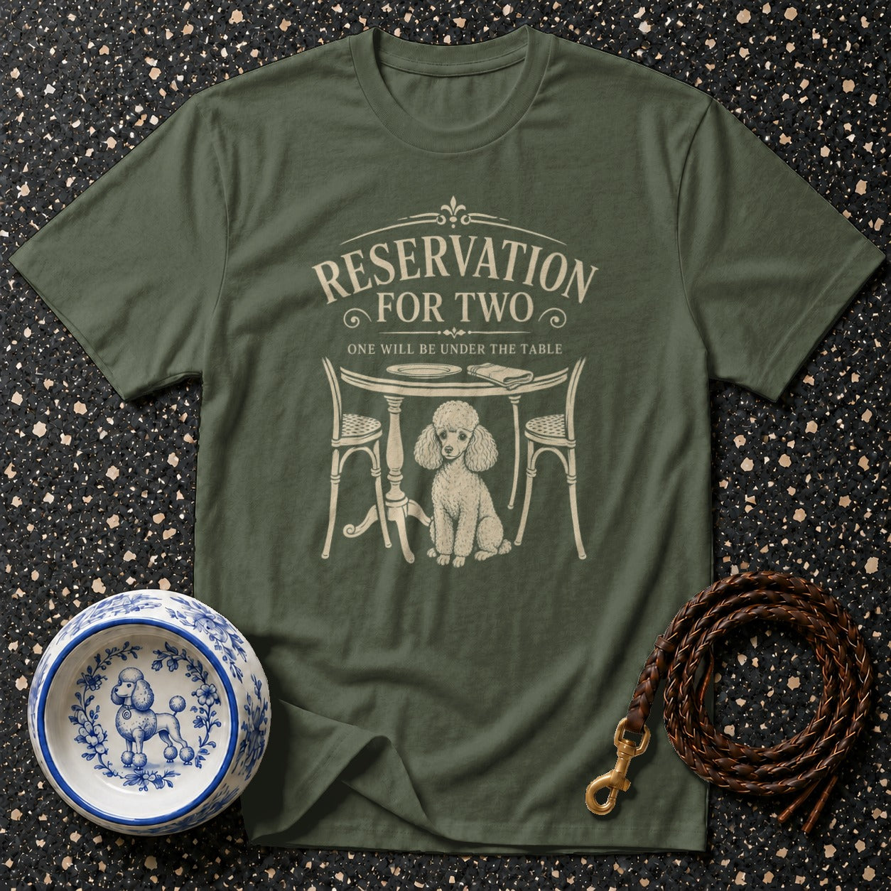 Green t-shirt with cream graphic of a poodle under a table that reads "Reservation For Two".