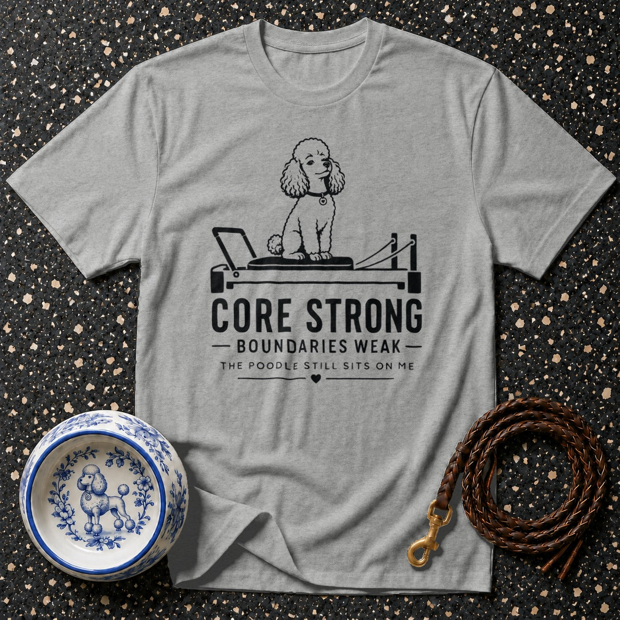 Grey t-shirt with poodle on a pilates reformer and text "Core Strong"