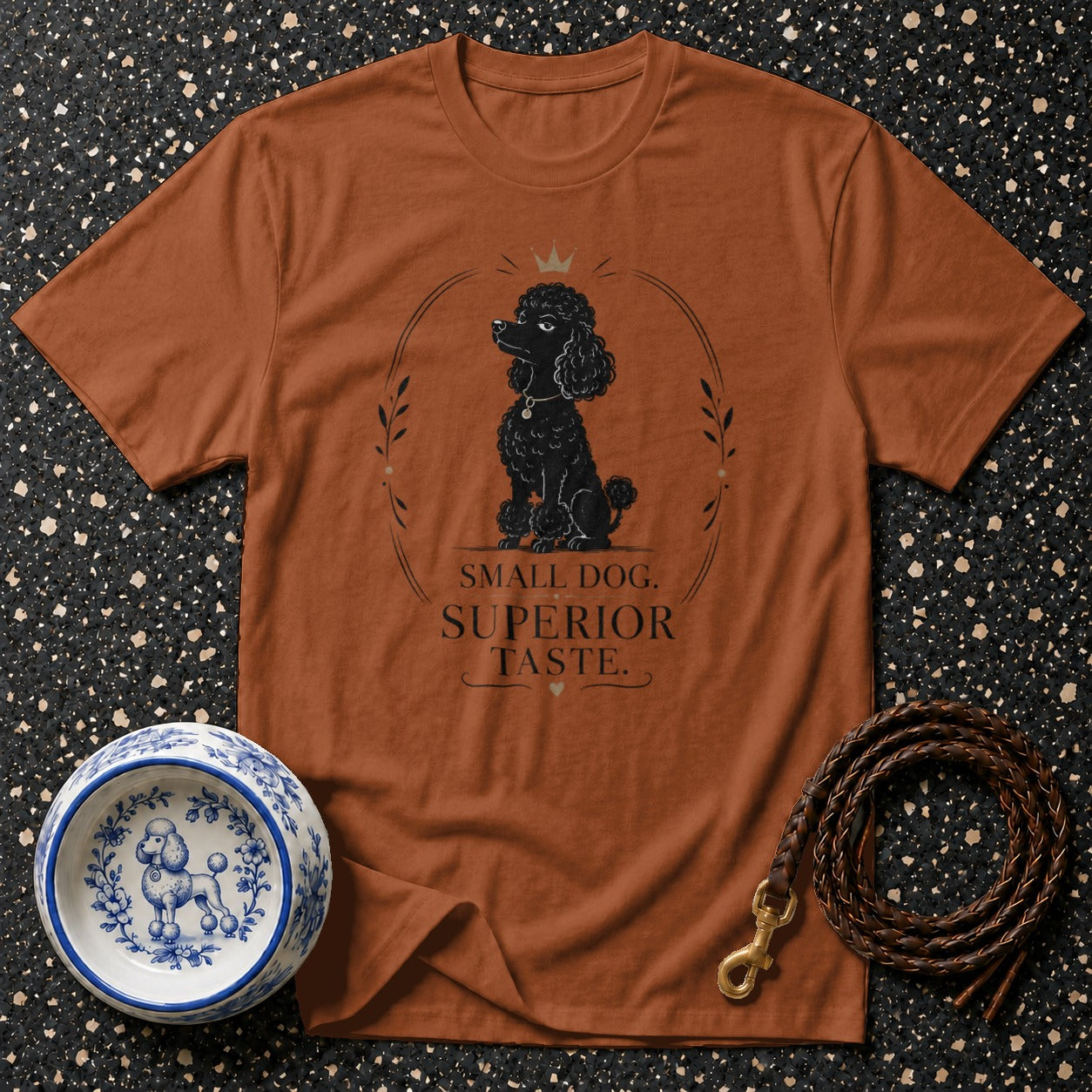 Brown t-shirt with black poodle illustration and text "SMALL DOG. SUPERIOR TASTE."