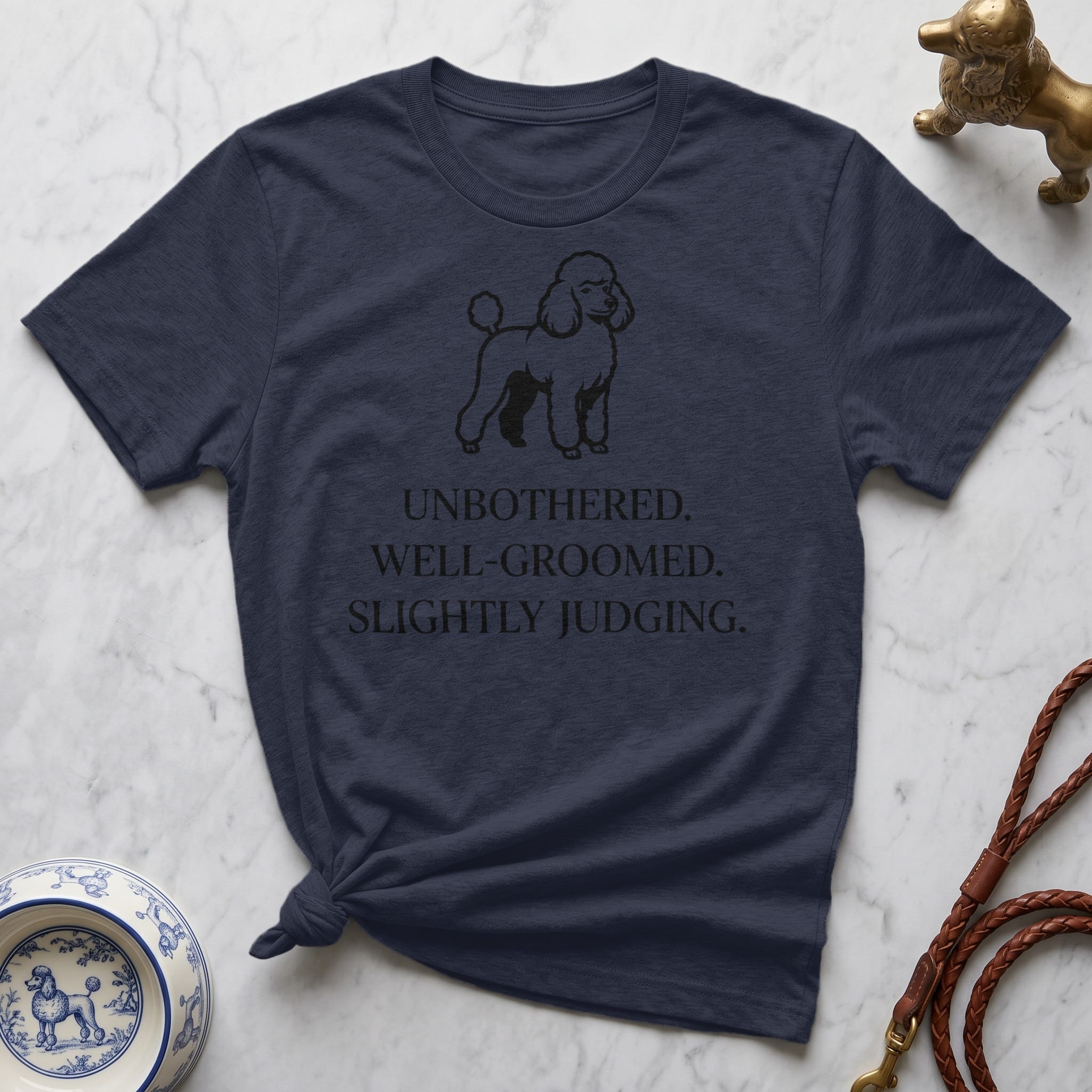 Navy t-shirt with a poodle illustration and text "UNBOTHERED. WELL-GROOMED. SLIGHTLY JUDGING."