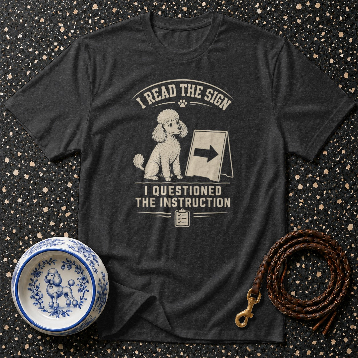 Dark t-shirt with poodle graphic and text "I READ THE SIGN I QUESTIONED THE INSTRUCTION".
