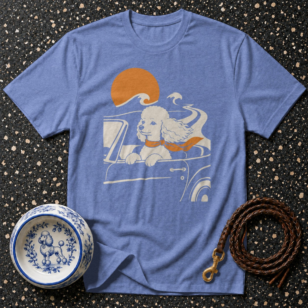 Blue t-shirt with a white poodle driving a car with an orange scarf and sun.