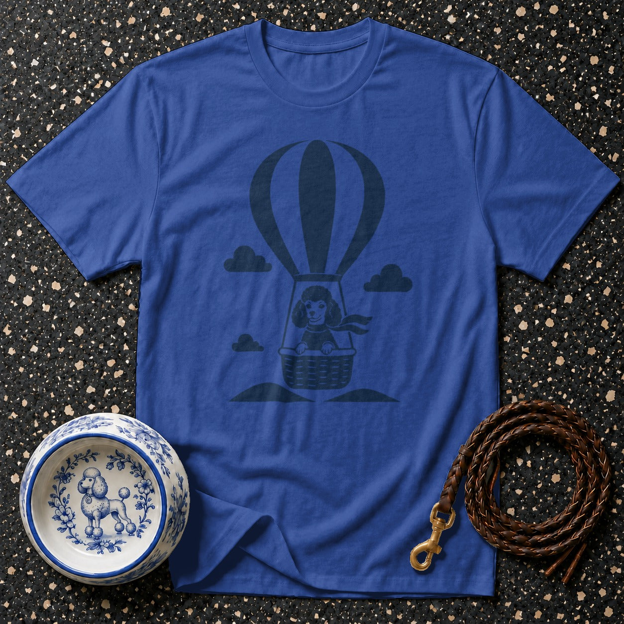 Blue t-shirt with a dark blue graphic of a poodle in a hot air balloon.