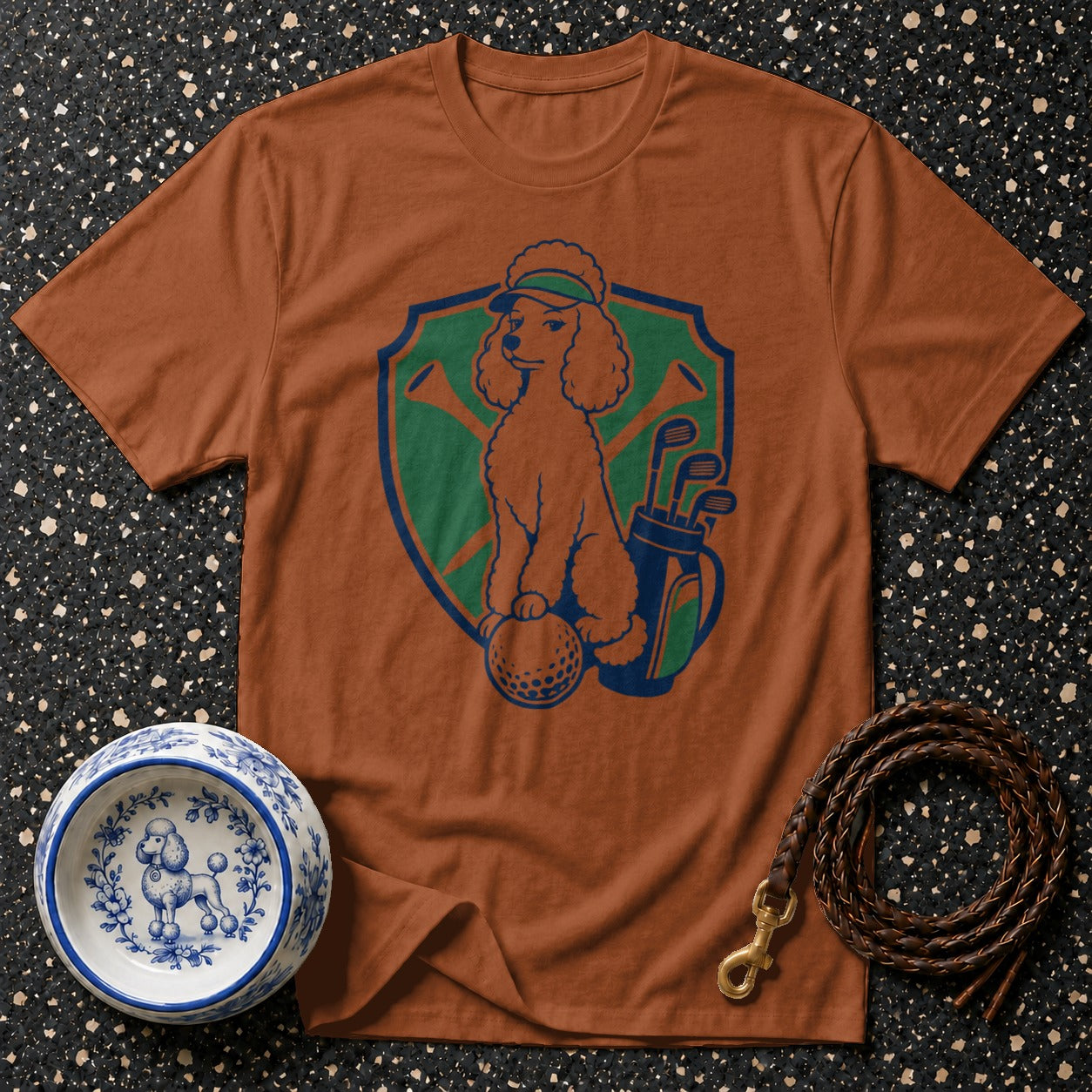 Brown t-shirt with a poodle playing golf graphic in a shield emblem.