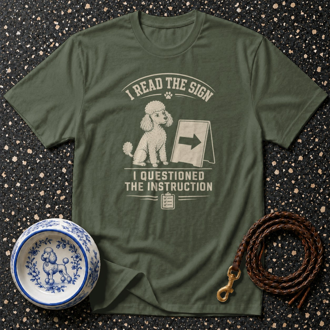 Olive green t-shirt with a poodle design and text: "I READ THE SIGN. I QUESTIONED THE INSTRUCTION."
