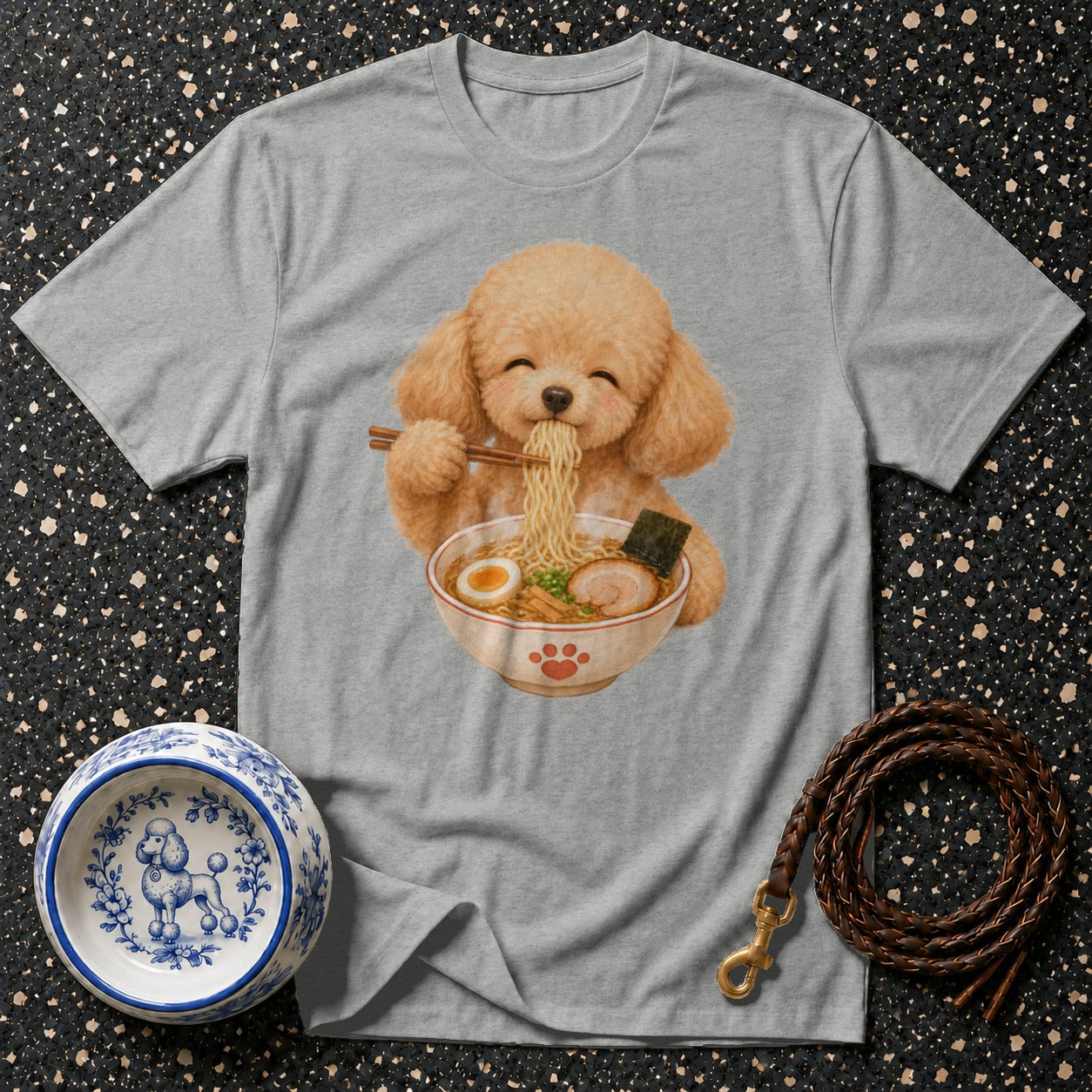 Grey t-shirt with illustration of poodle eating ramen, dog bowl, and leather leash.