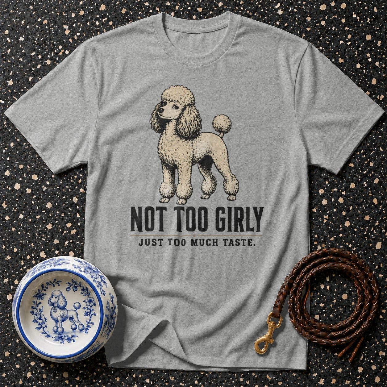Grey t-shirt with a poodle illustration that reads "NOT TOO GIRLY JUST TOO MUCH TASTE."