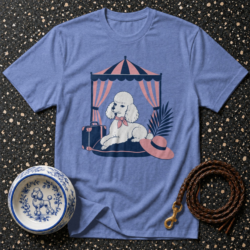 Blue t-shirt with white poodle graphic under a striped tent with a suitcase and hat.