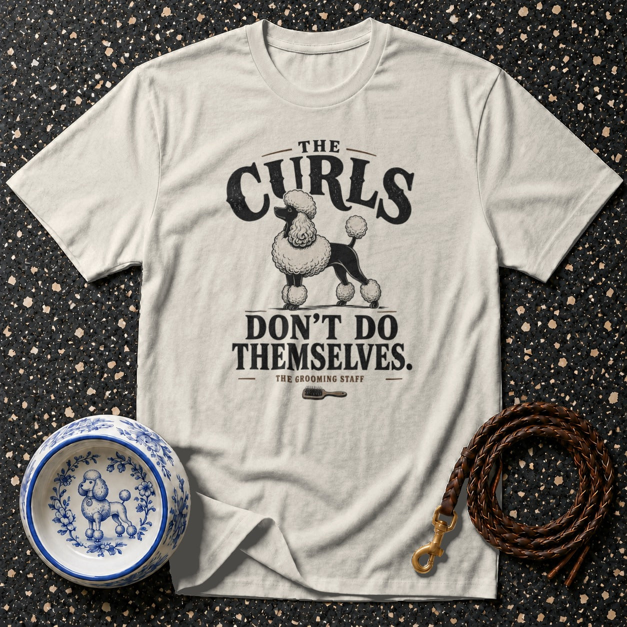 Light-colored t-shirt with black poodle graphic and text "The Curls Don't Do Themselves."