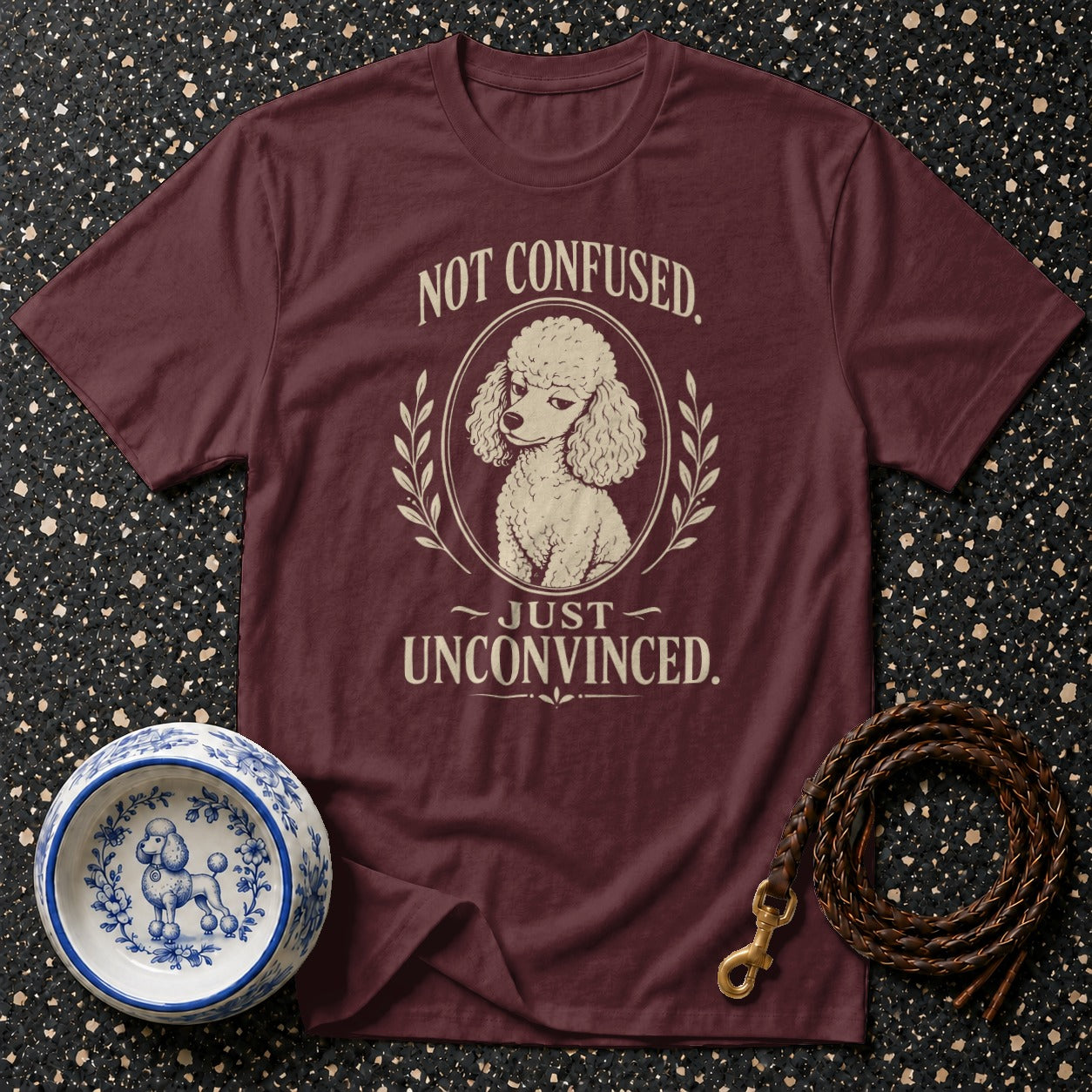 Maroon t-shirt with a poodle graphic and text "Not Confused. Just Unconvinced."