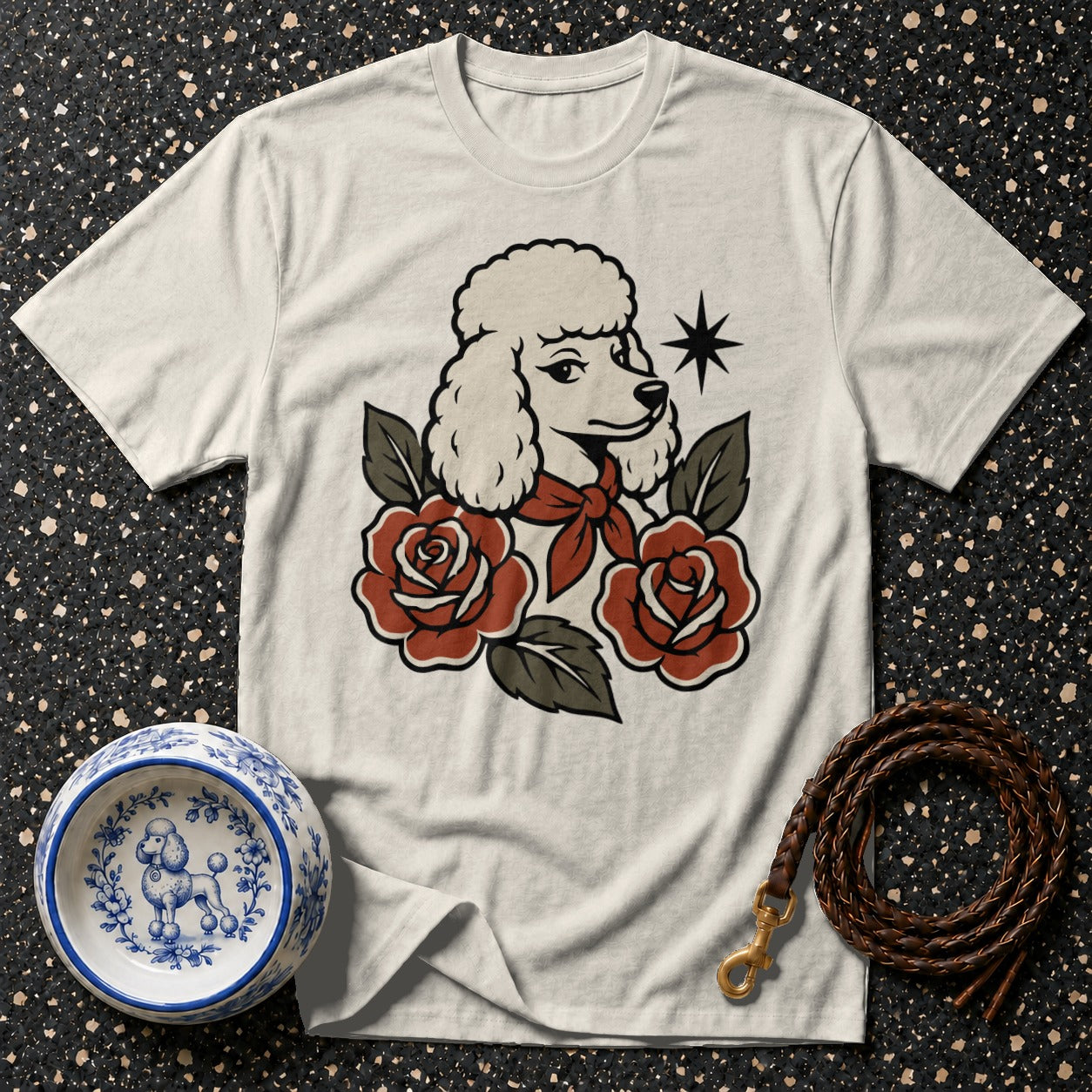 Cream t-shirt with a poodle, roses, and star graphic, plus dog bowl and leash.
