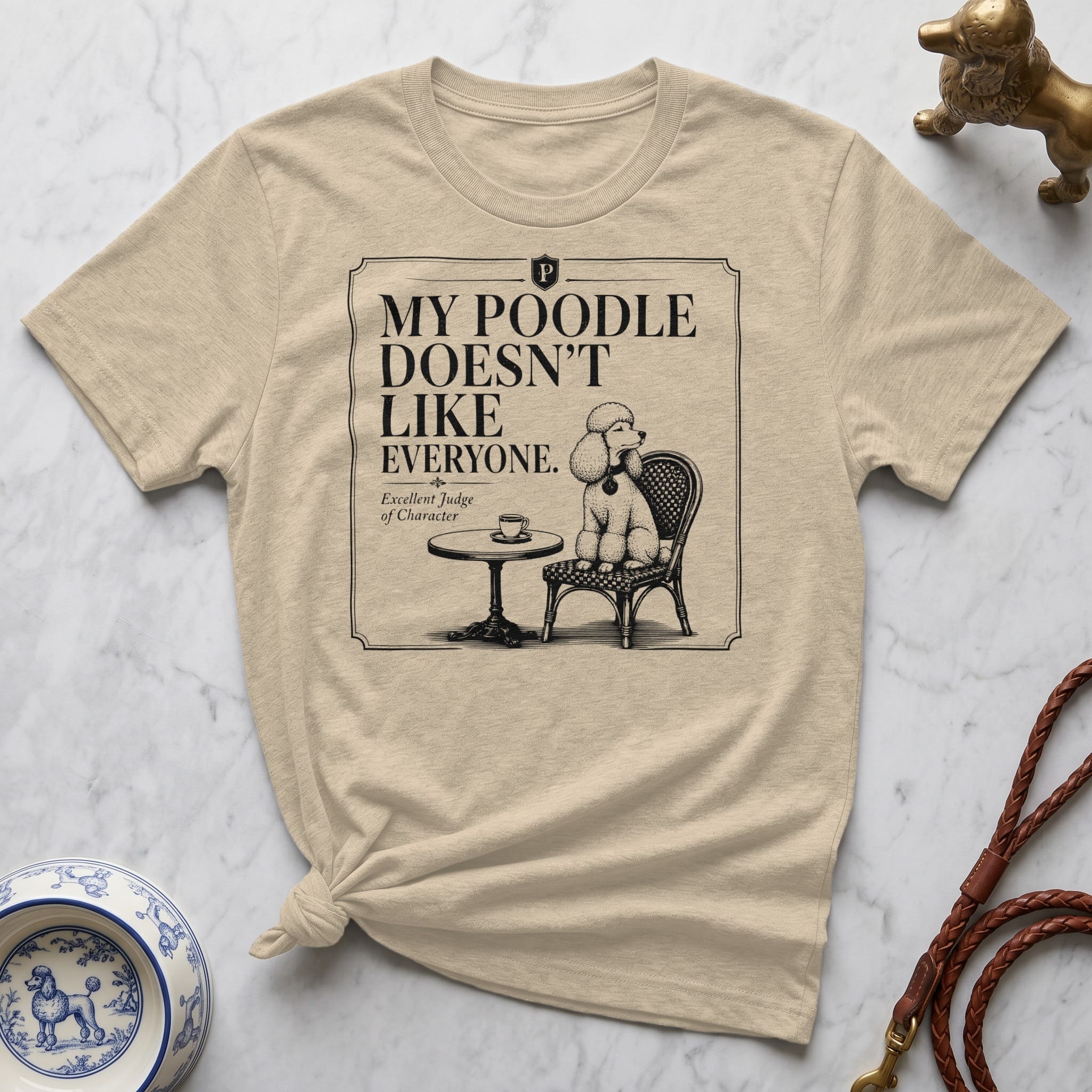 Beige t-shirt with "My Poodle Doesn't Like Everyone" text and poodle illustration.