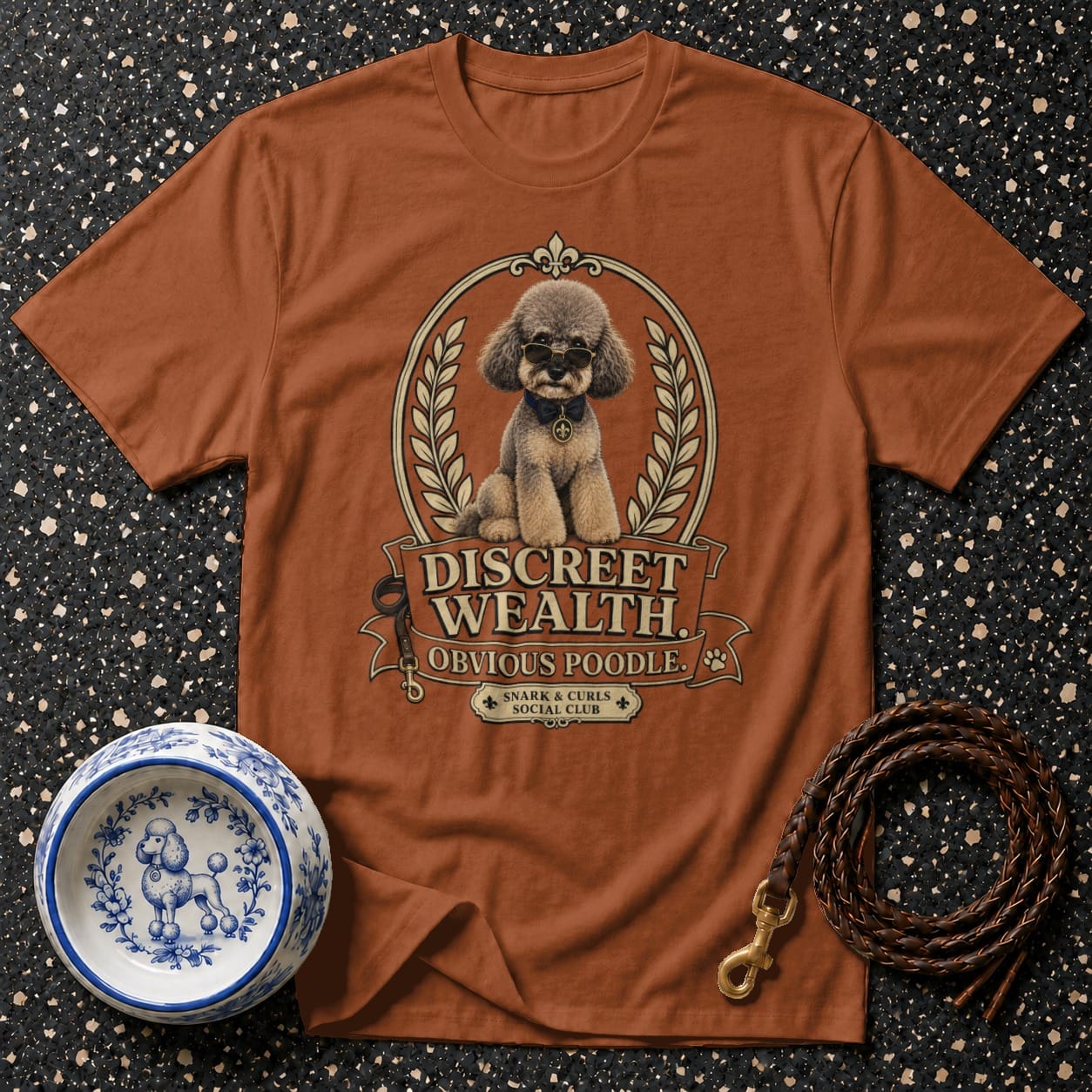 Brown t-shirt with a poodle wearing sunglasses and text "Discreet Wealth".