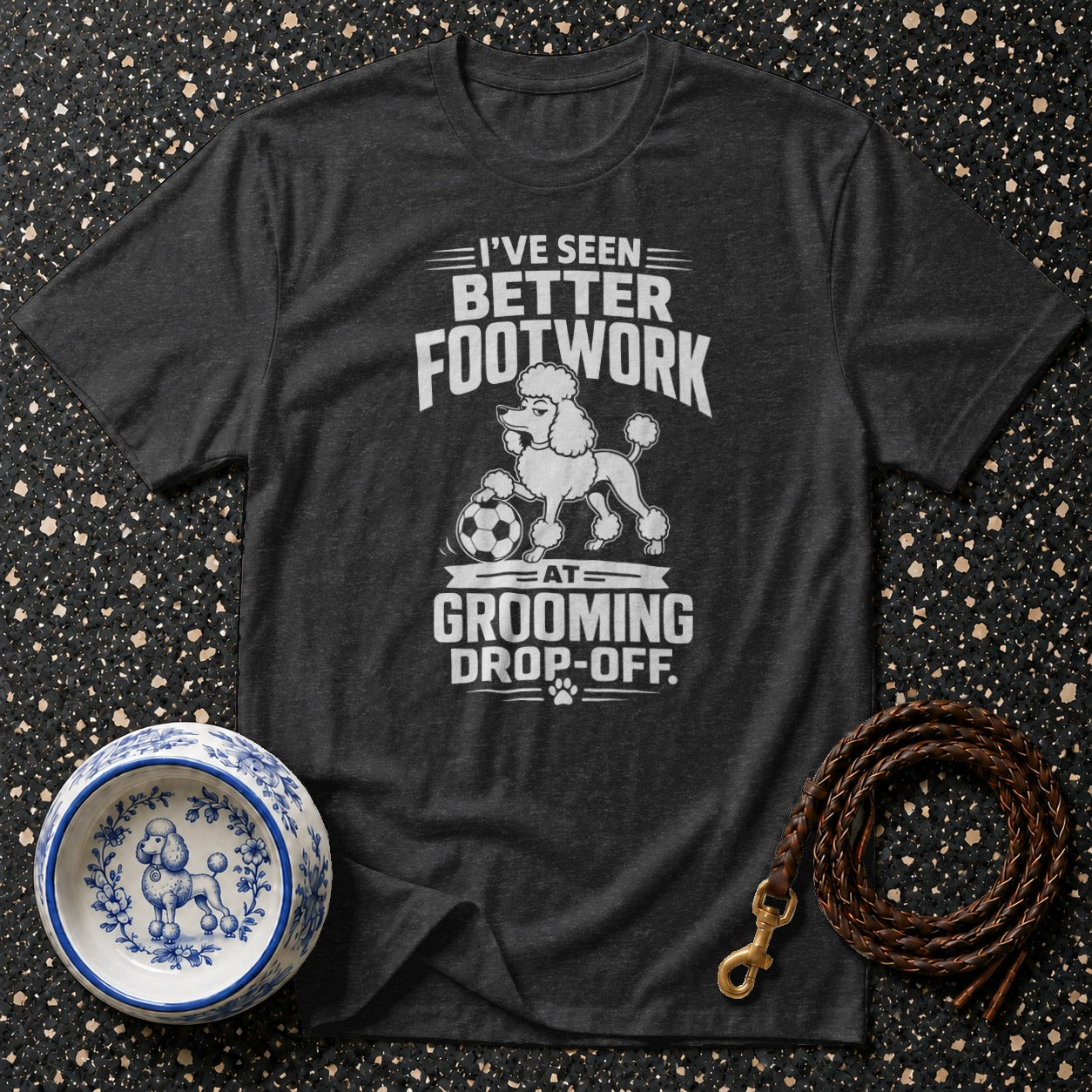 Dark gray t-shirt with white text: "I'VE SEEN BETTER FOOTWORK AT GROOMING DROP-OFF."