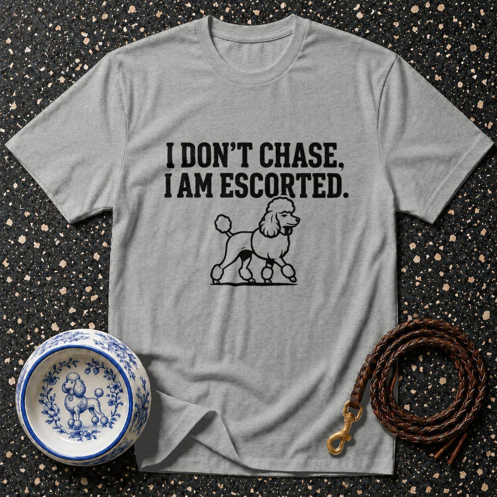 Grey t-shirt with text "I DON'T CHASE, I AM ESCORTED" and a poodle illustration.