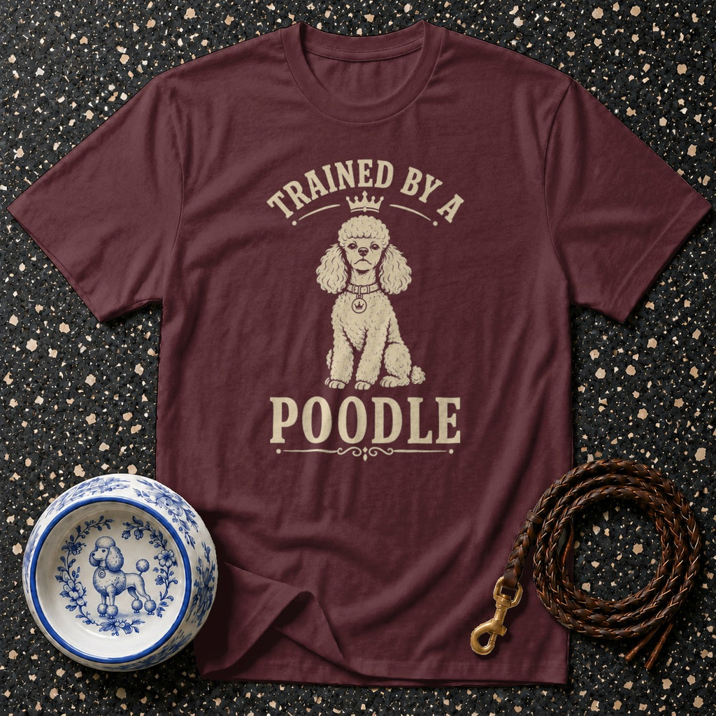 Maroon t-shirt with a poodle graphic and text "TRAINED BY A POODLE."