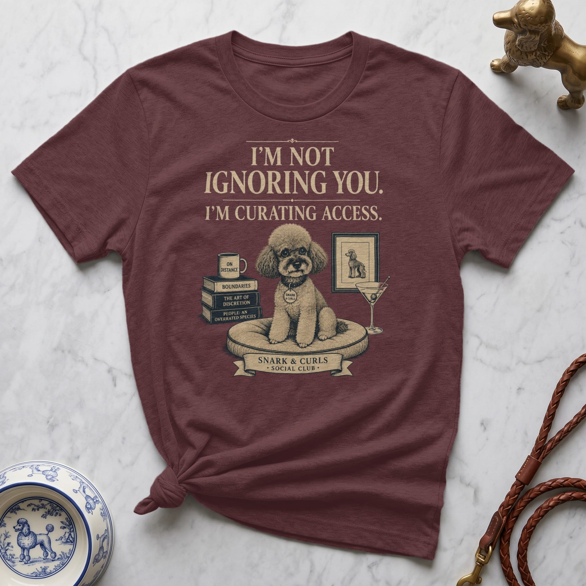 Maroon t-shirt with text about curating access and books.