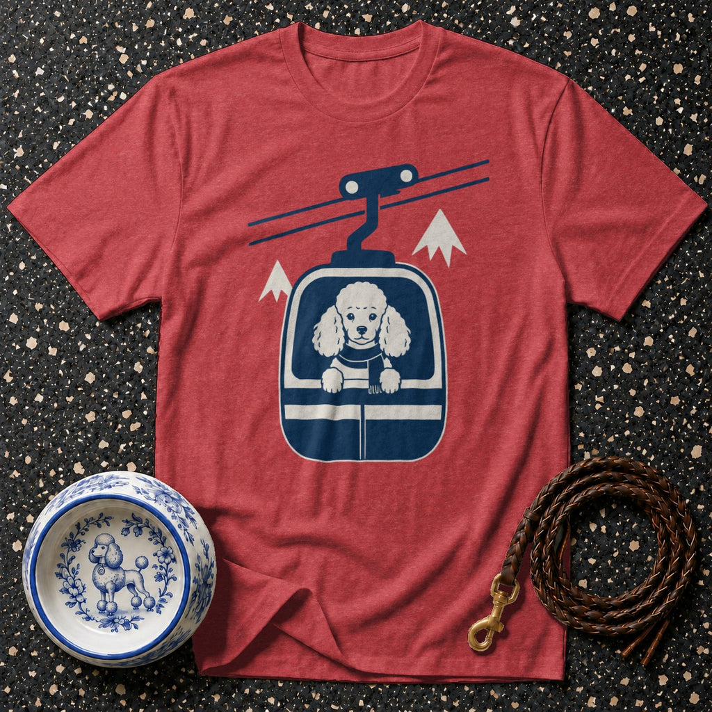 Red t-shirt with a poodle in a ski lift graphic, next to a dog bowl and leash.