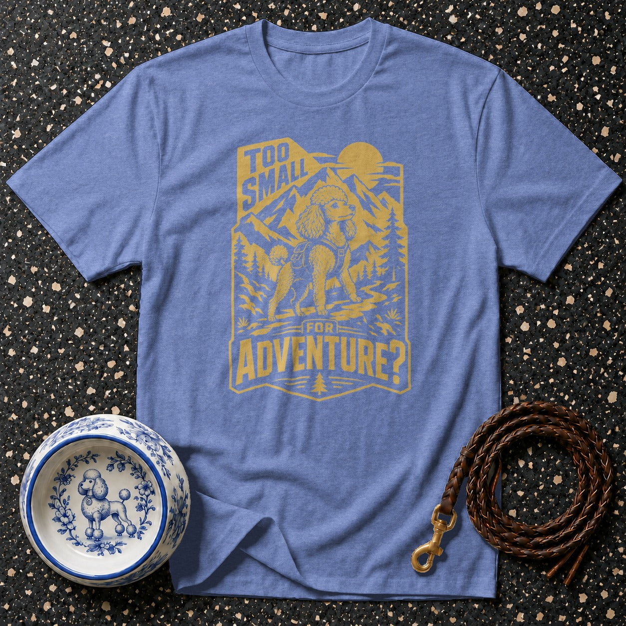 Blue t-shirt with yellow graphic of a poodle in mountains saying "Too Small For Adventure?".