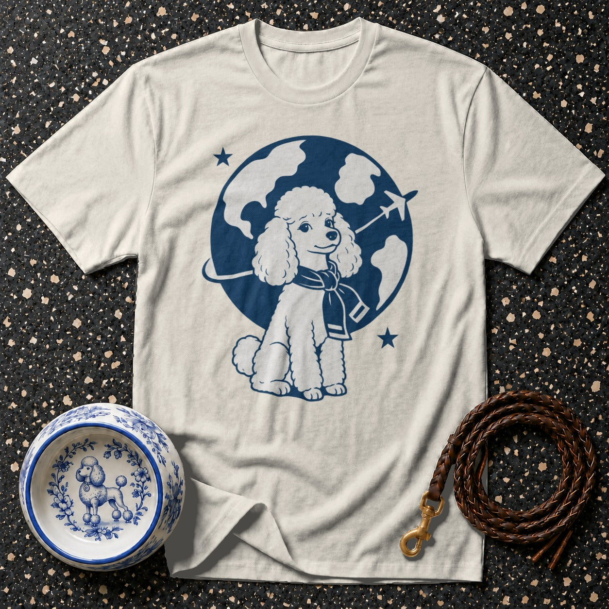 Cream t-shirt with blue poodle graphic wearing a scarf and scarf around a globe.