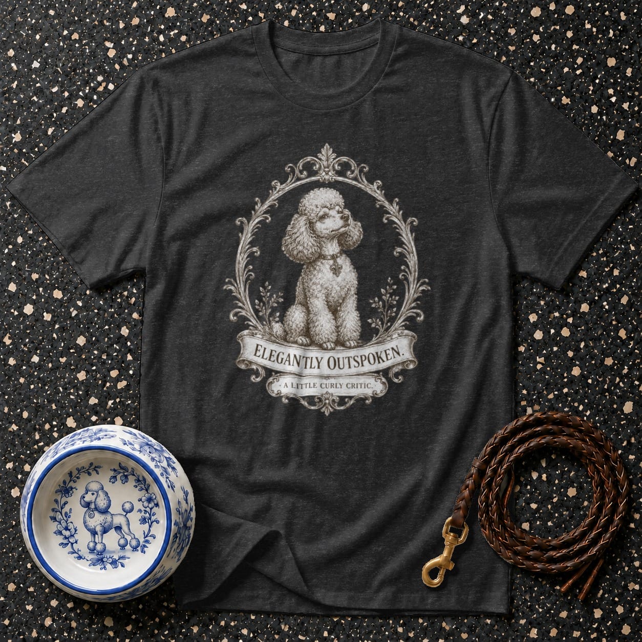 Dark grey t-shirt with framed poodle graphic and "ELEGANTLY OUTSPOKEN." text.