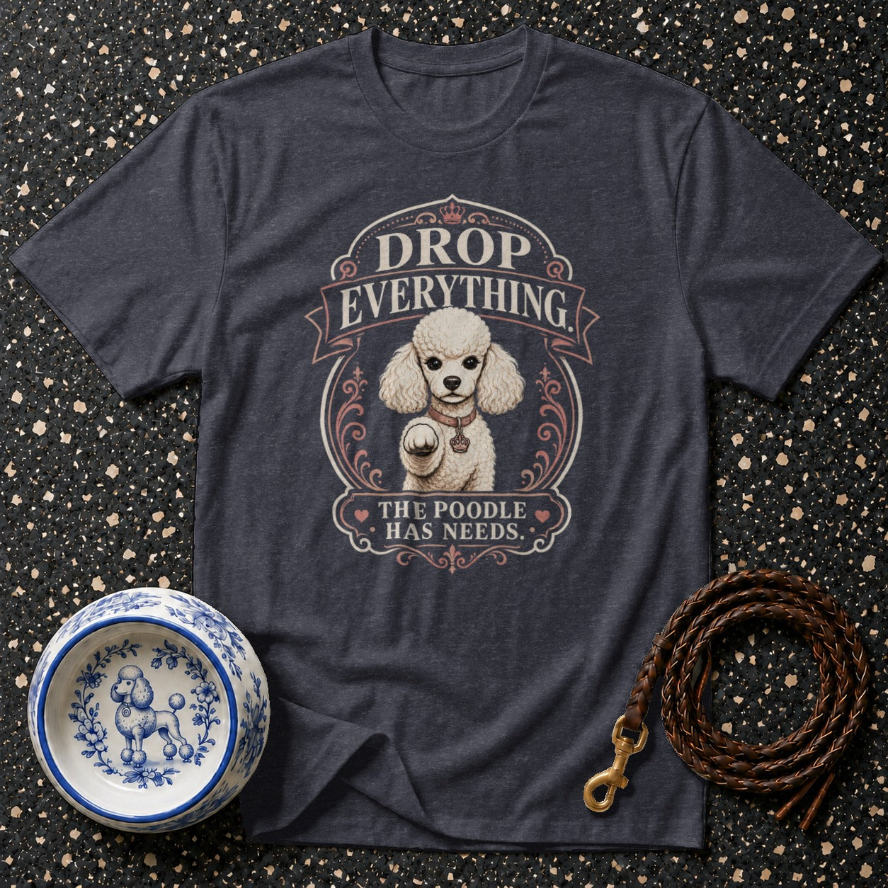 Dark t-shirt with poodle graphic and text "DROP EVERYTHING THE POODLE HAS NEEDS."