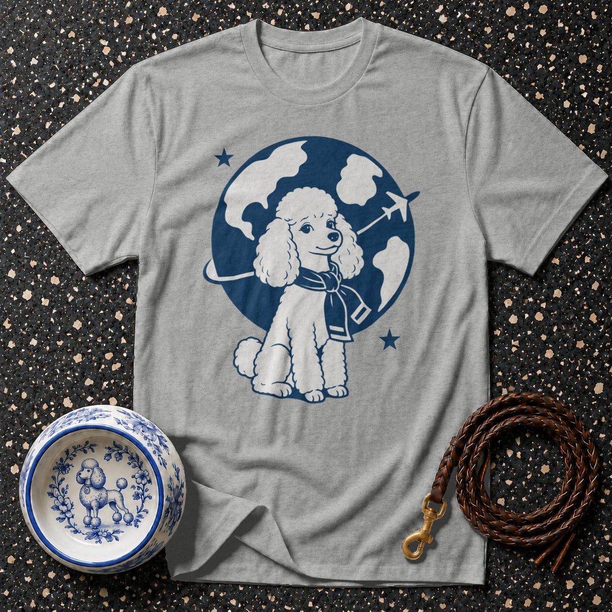 Grey t-shirt with a white poodle and globe graphic and a brown braided leash.