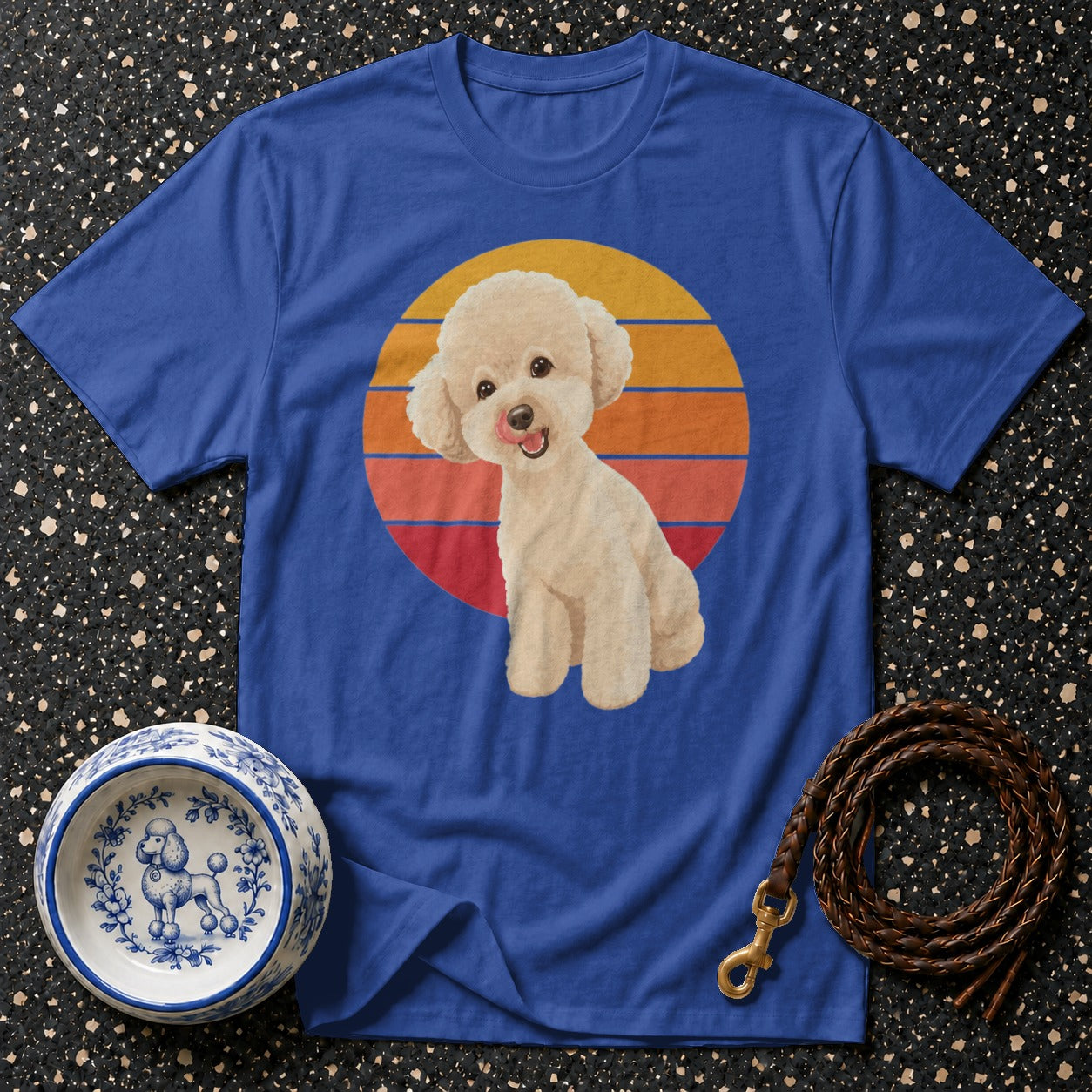 Blue t-shirt with cream poodle illustration against a retro sunset circle.