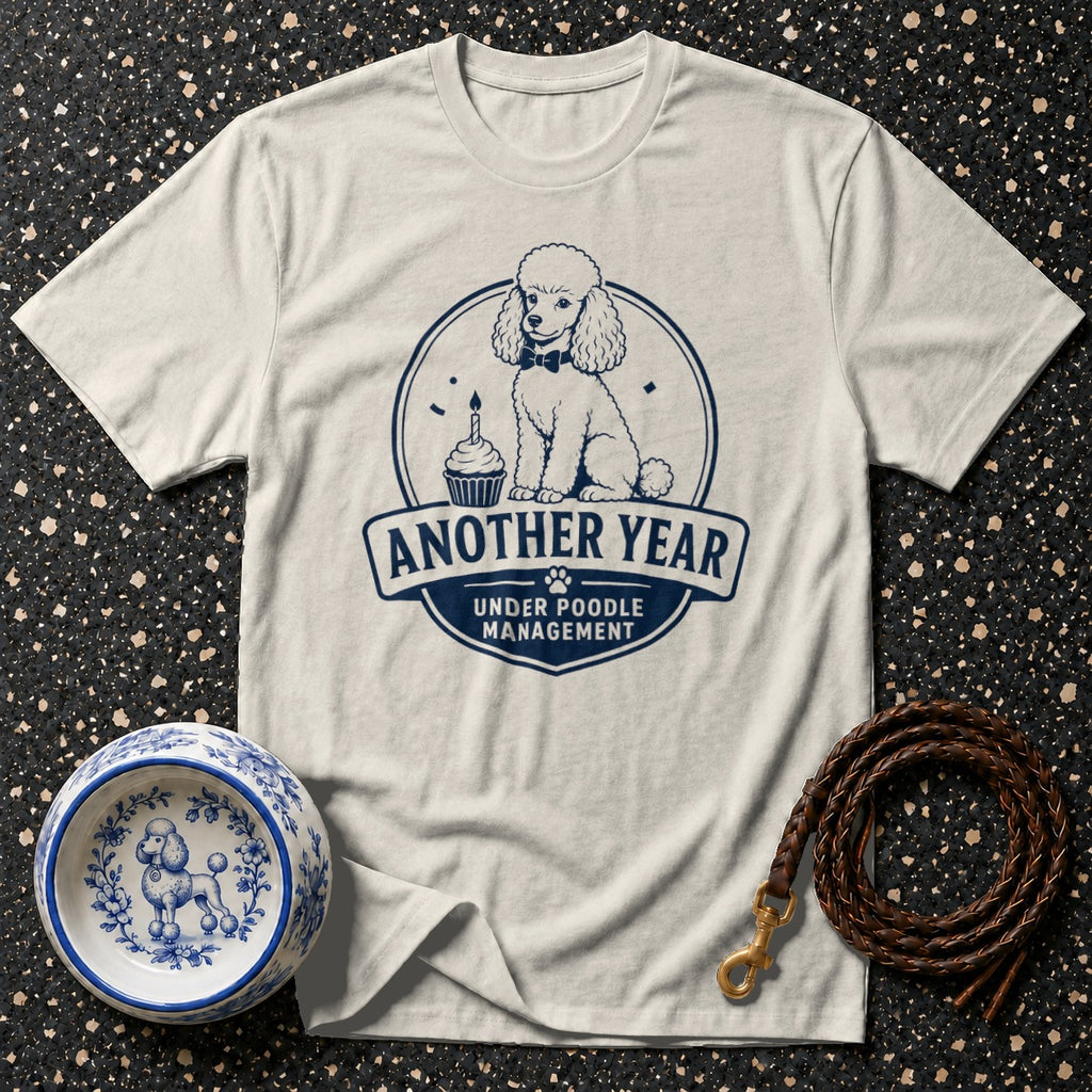 Cream t-shirt with dark blue poodle graphic: "Another year under poodle management."