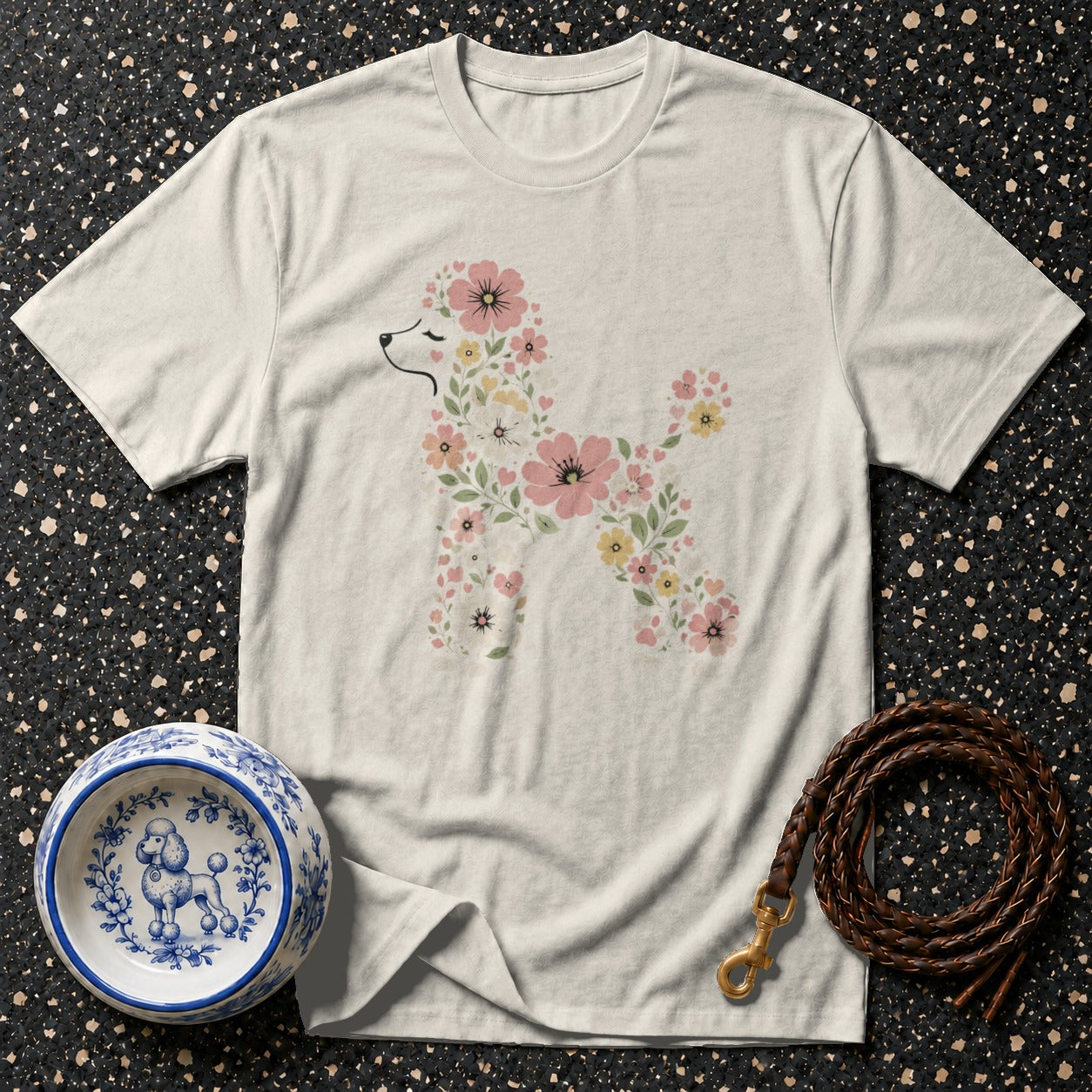 Light-colored t-shirt with a floral poodle graphic, dog bowl, and leather leash.