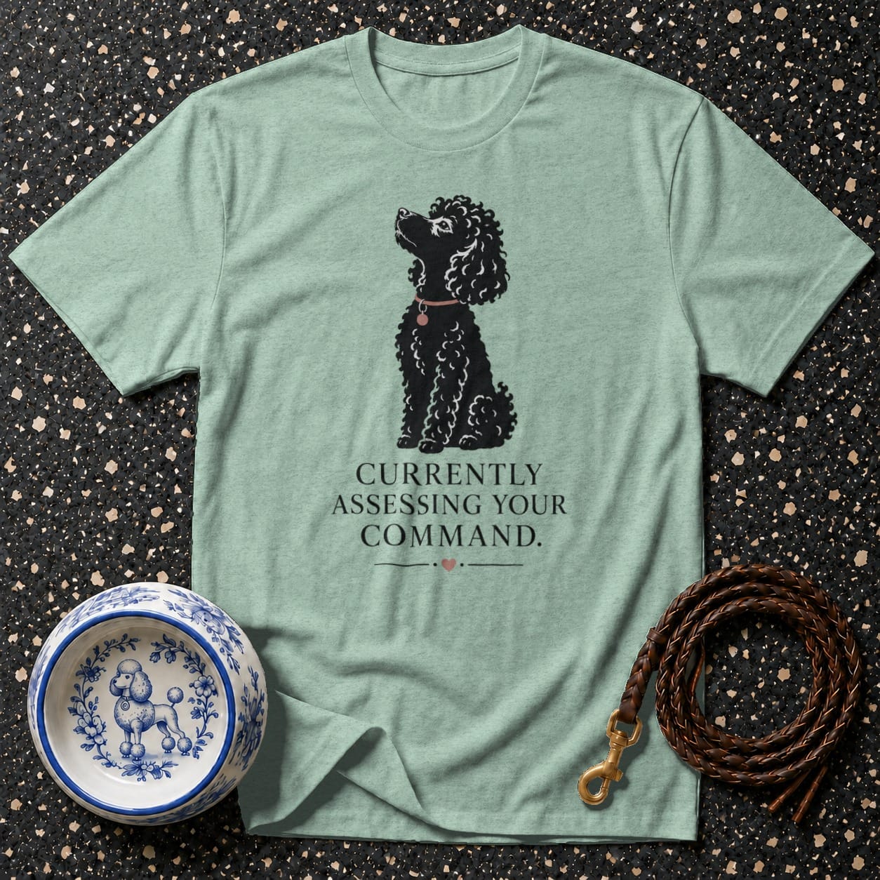 Mint t-shirt with black poodle graphic and text "CURRENTLY ASSESSING YOUR COMMAND.".