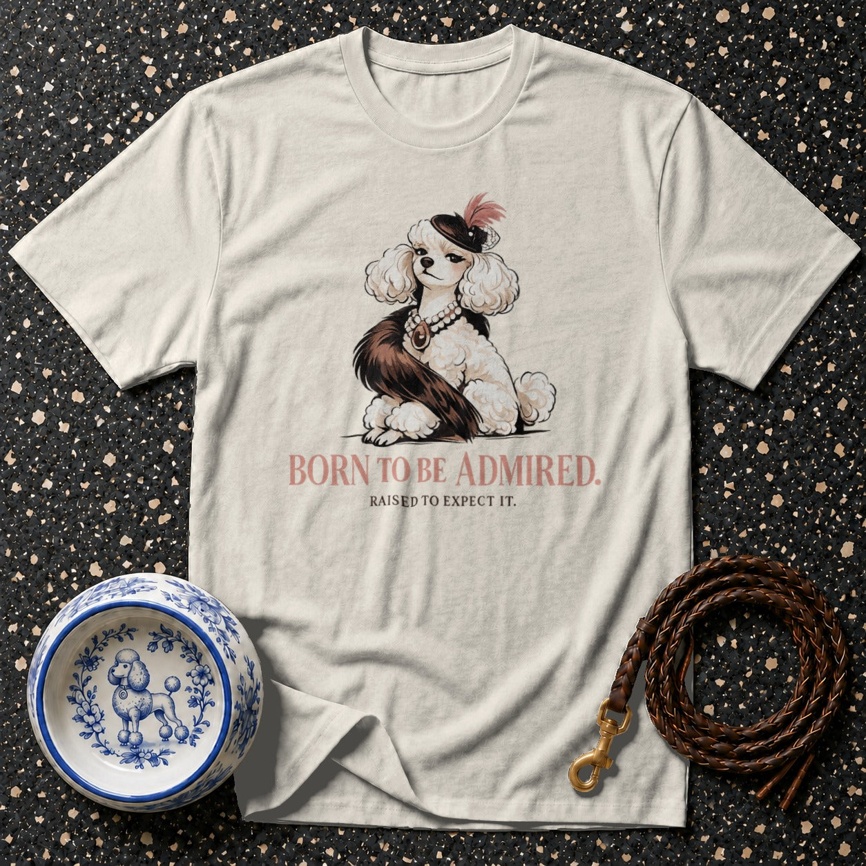 Cream t-shirt with a poodle graphic and text "BORN TO BE ADMIRED. RAISED TO EXPECT IT."