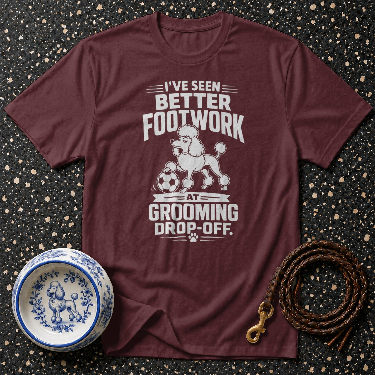 Maroon t-shirt with white text and poodle graphic: "I've seen better footwork at grooming drop-off."