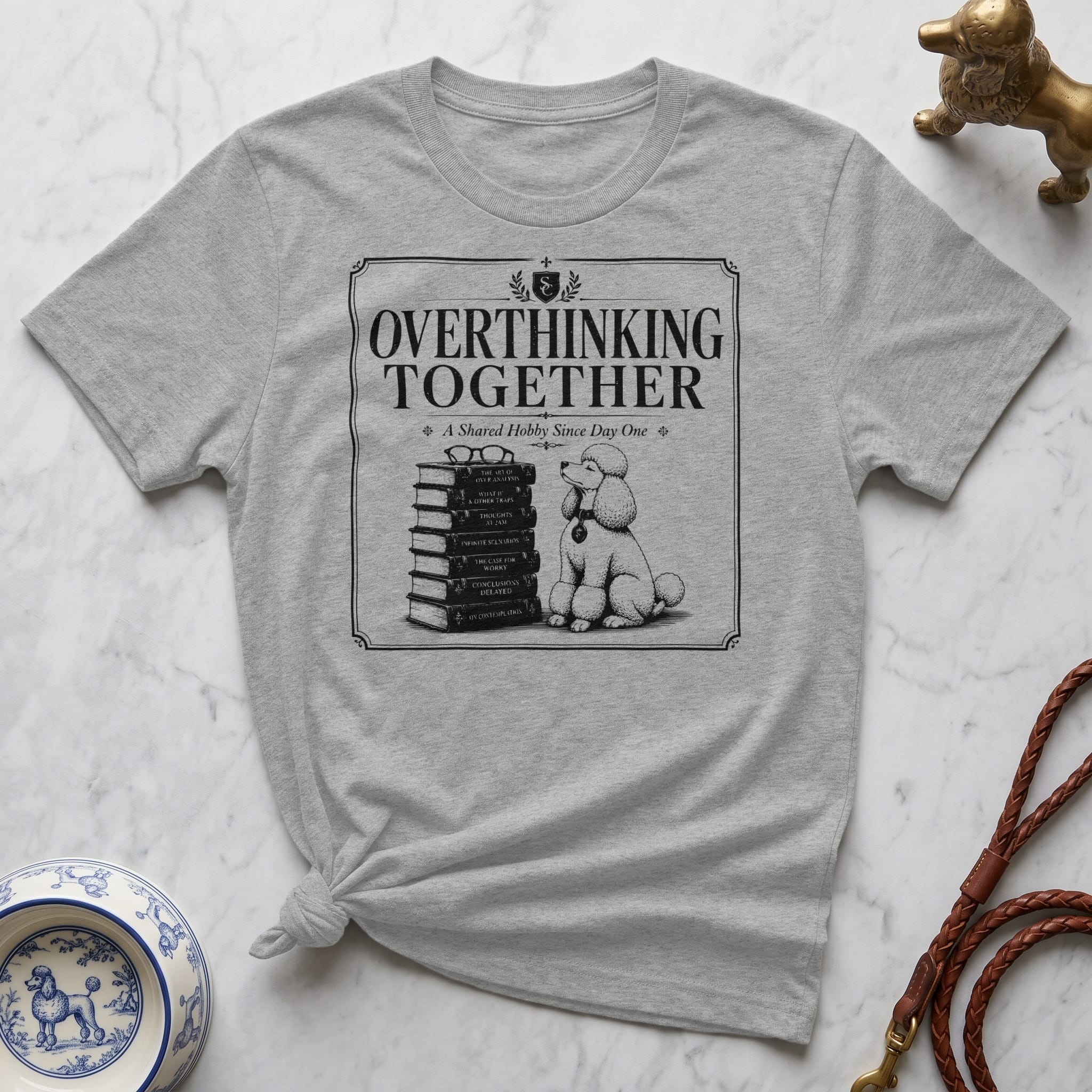 T-shirt with "Overthinking Together" text and a poodle next to a stack of books.