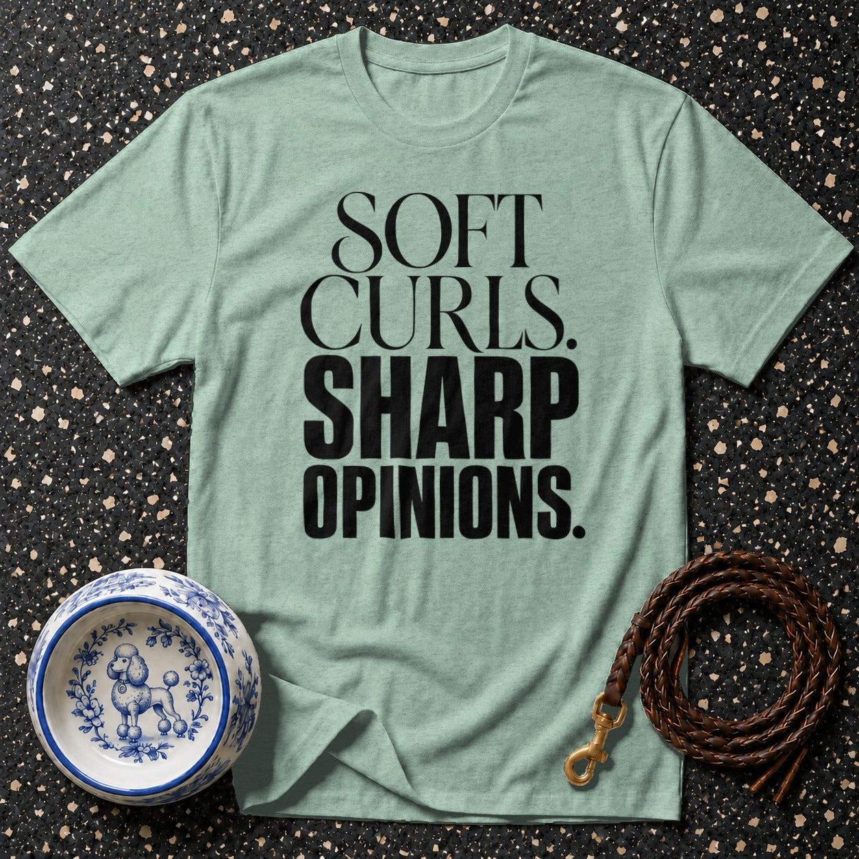 Light green t-shirt with black text "SOFT CURLS. SHARP OPINIONS."